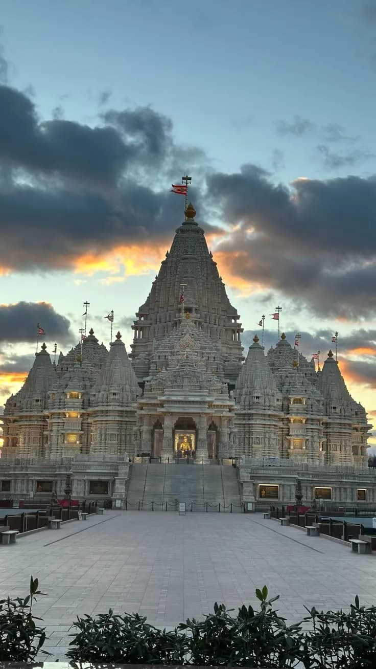 A grand carved stone temple with many spires under a dramatic evening sky